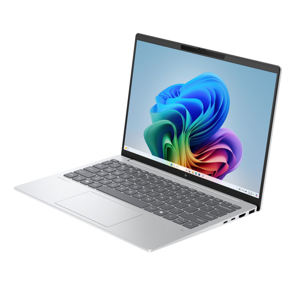 Srebrny laptop z kolorową tapetą na ekranie.