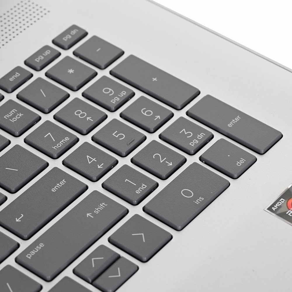 Zbliżenie na szarą klawiaturę laptopa z klawiaturą numeryczną i strzałkami.