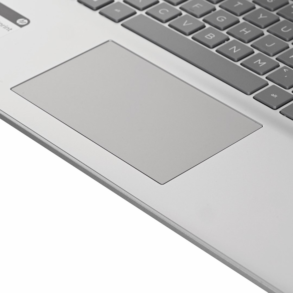 Zbliżenie srebrnej klawiatury i gładzika laptopa. Szare klawisze i gładzik na metalowej powierzchni.