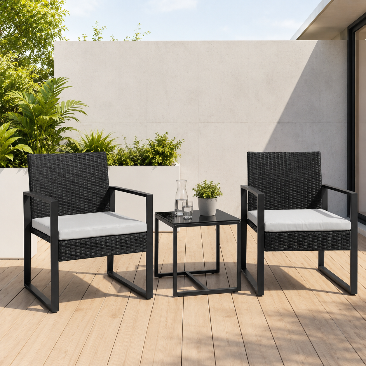 Dos sillas negras de ratán con cojines blancos y una mesa pequeña en una terraza de madera.