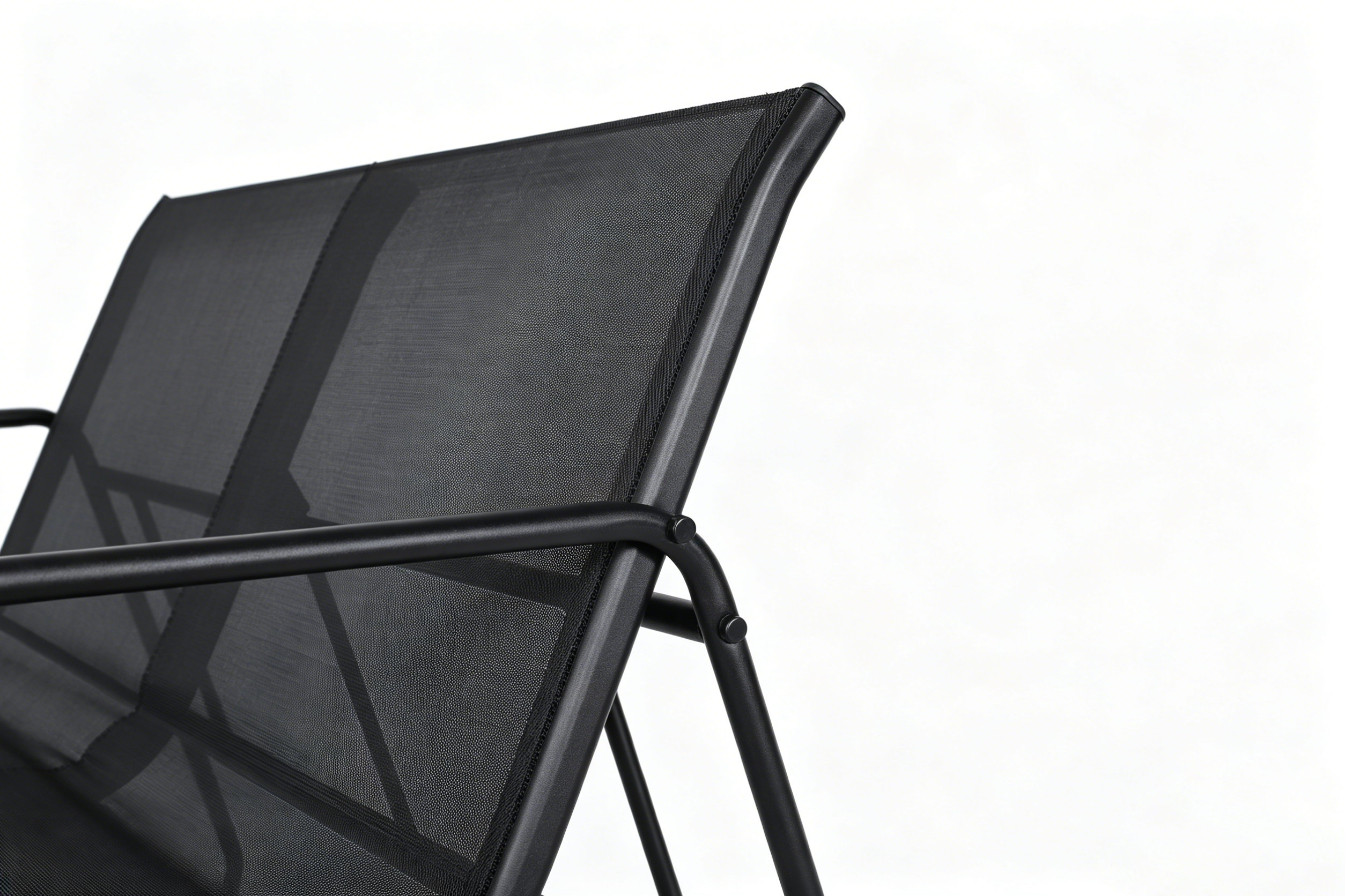 Una silla negra de malla con marco de metal, vista cercana.