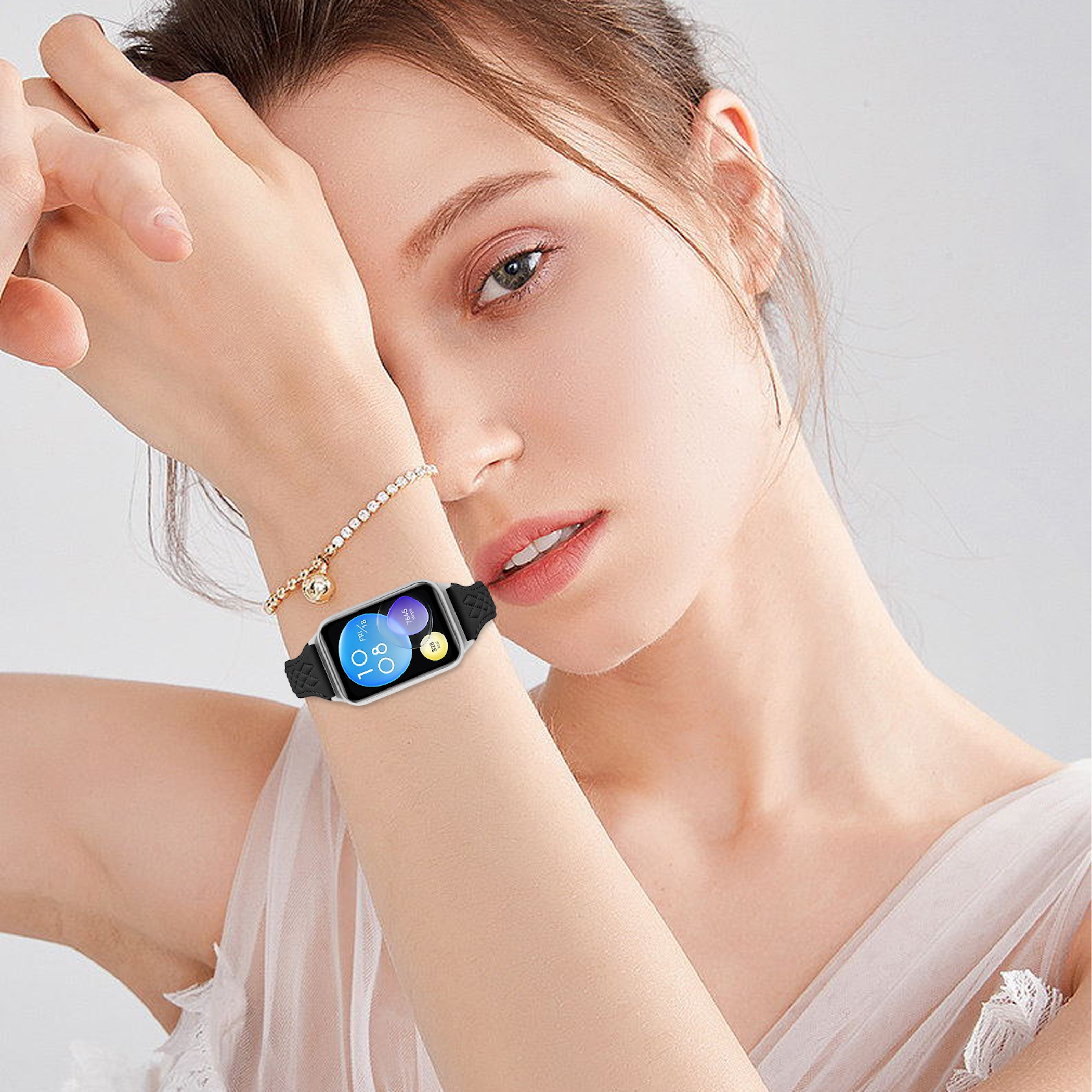 Frau mit Armbanduhr und Schmuckband am Handgelenk, weißem Kleid.