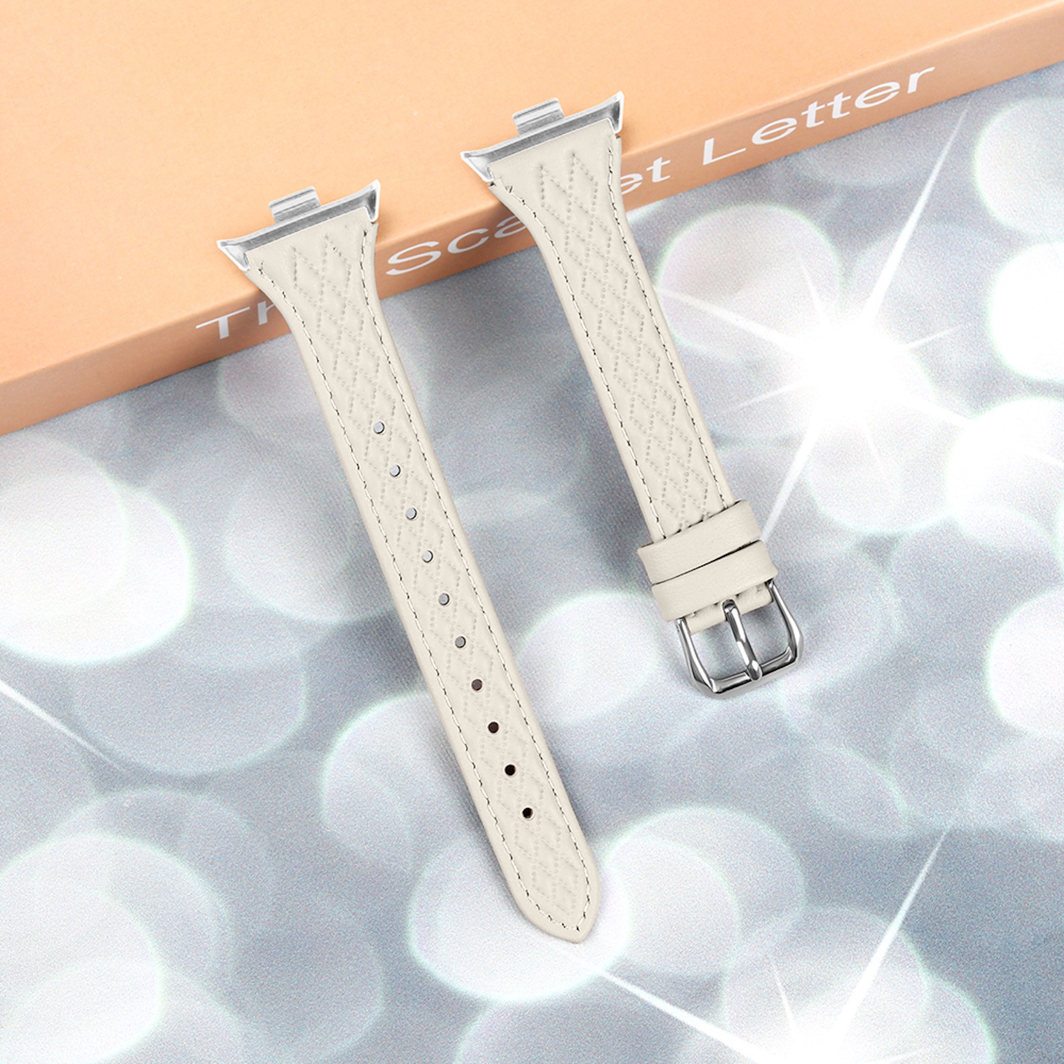 Zwei cremefarbene Uhrenarmbänder mit Rautenmuster und Metallschnallen.