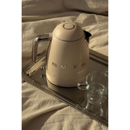 Ein cremefarbener Smeg-Wasserkocher und eine Tasse auf einem Tablett.