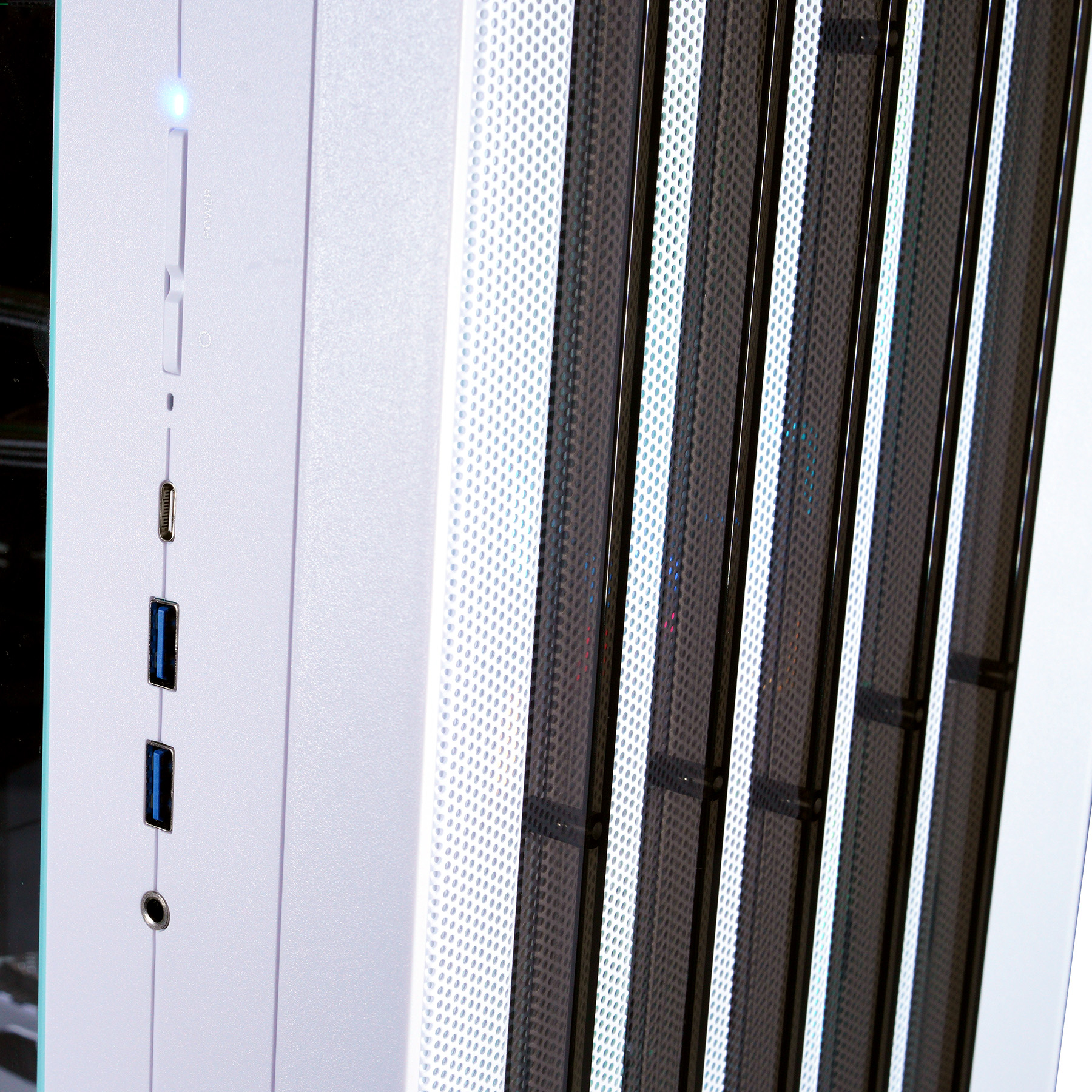 Weiße PC-Gehäuseseite mit USB-Anschlüssen und Lüftergitter.