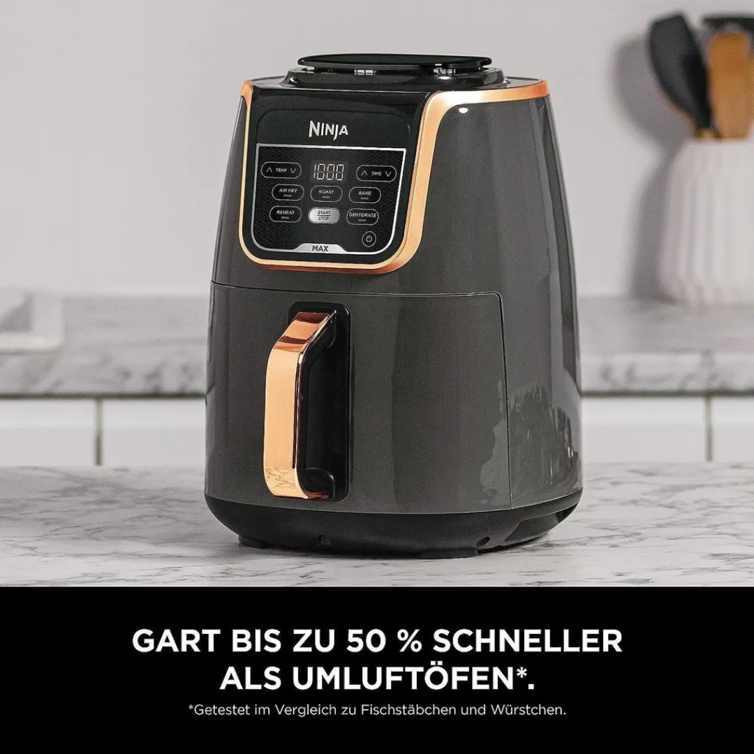 Eine anthrazitfarbene Ninja Heißluftfritteuse mit Kupfergriff und Digitalanzeige steht auf einer Arbeitsplatte.