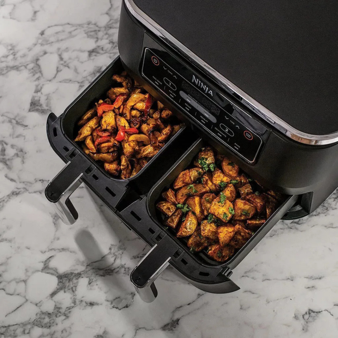 Ein Ninja Airfryer mit zwei Schubladen, gefüllt mit knusprigen Kartoffeln und Paprika.
