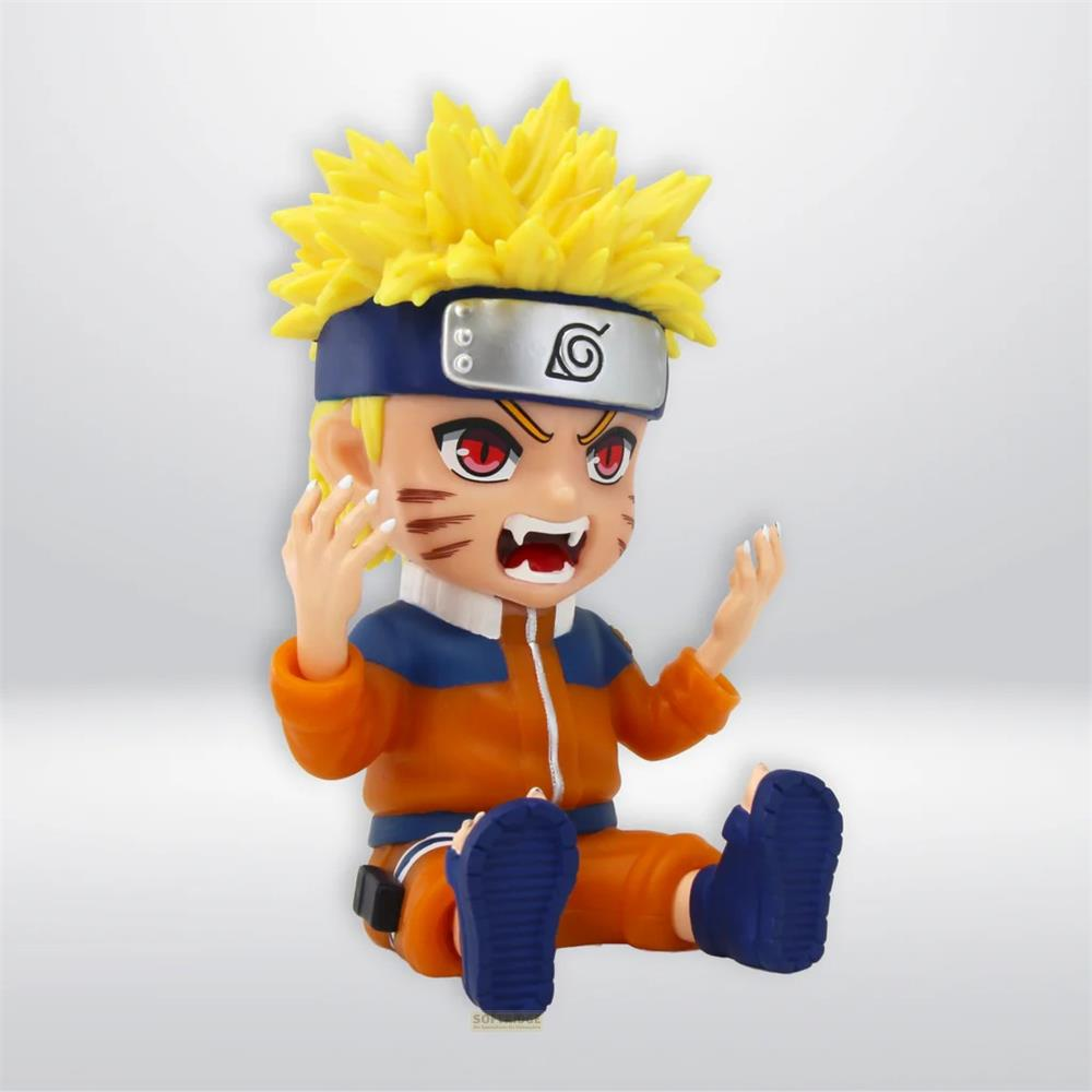 Una figura de Naruto con pelo amarillo y cinta roja se sienta en el suelo.