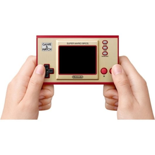 Manos sujetan un Game & Watch dorado con borde rojo. Super Mario Bros.