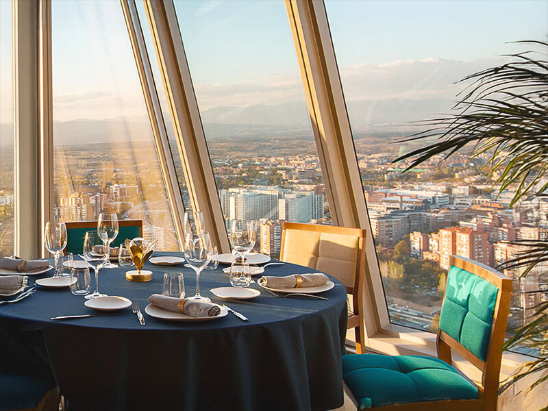 Una mesa puesta con vistas a una ciudad al atardecer.