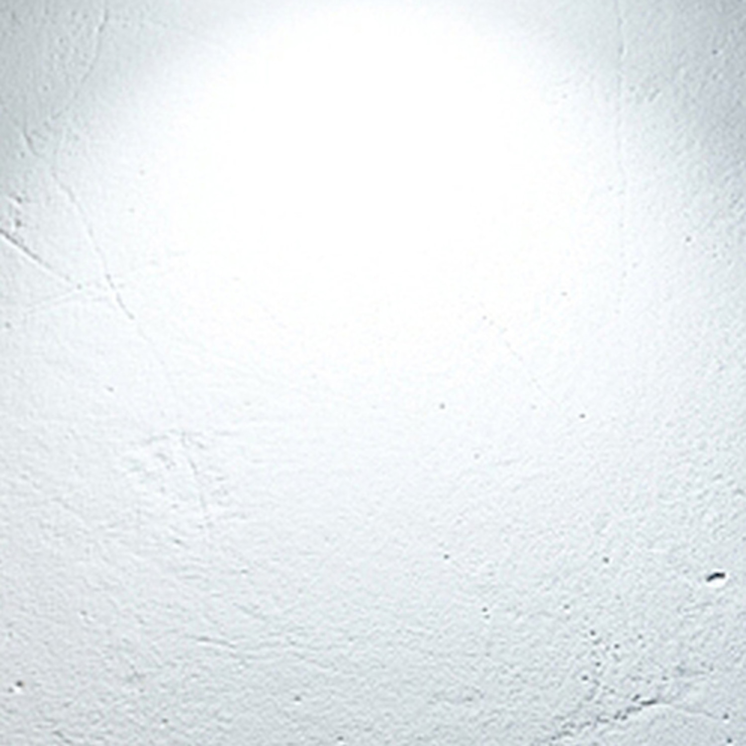 Un muro luminoso e testurizzato con effetto spotlight in alto.