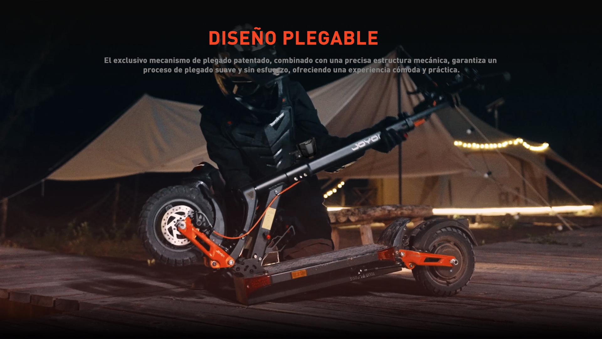 Persona con equipo de protección sostiene patinete ante tiendas de noche. Acentos naranjas.