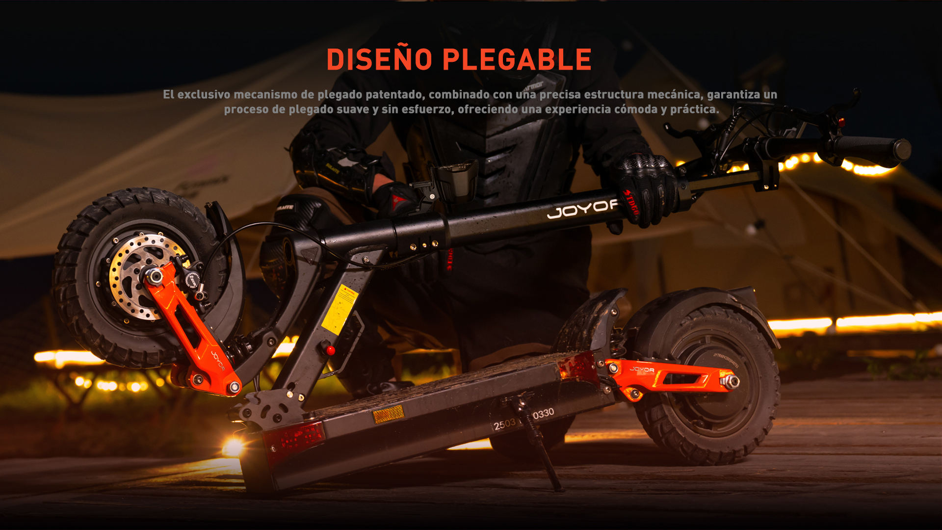 Una persona con equipo de protección sostiene un patinete plegable con detalles naranjas.