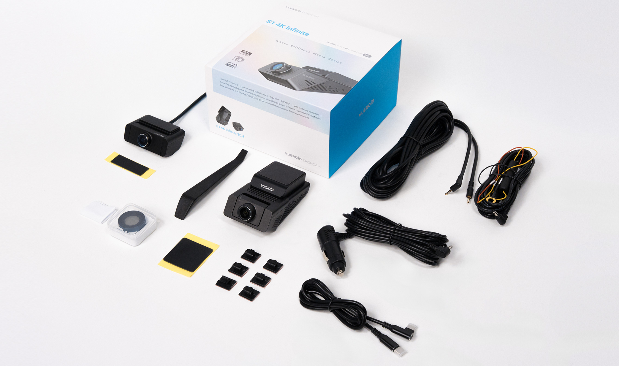 Dashcam accessoires: camera's, kabels, kleine onderdelen en een doos op witte achtergrond.