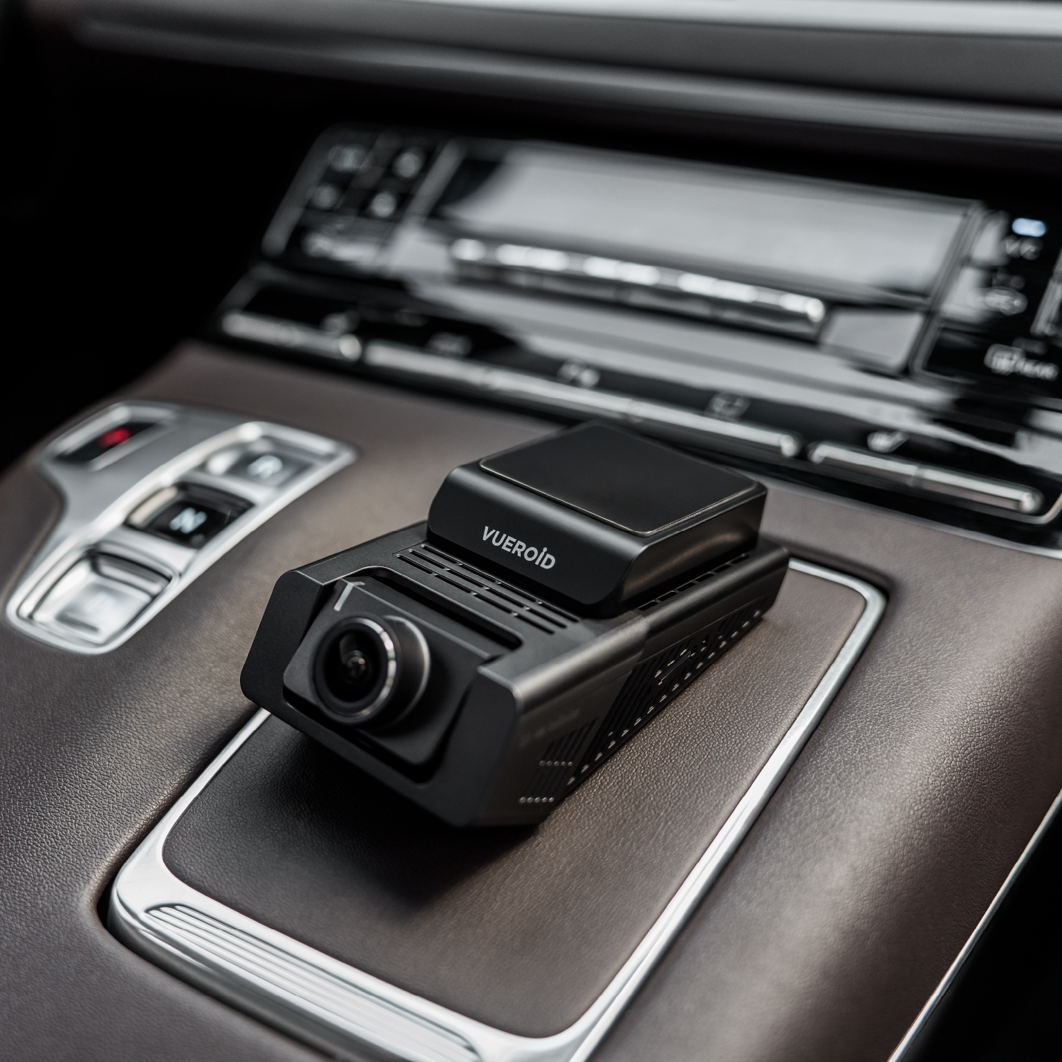 Een zwarte Vueroid autorecorder op bruin autoleer.