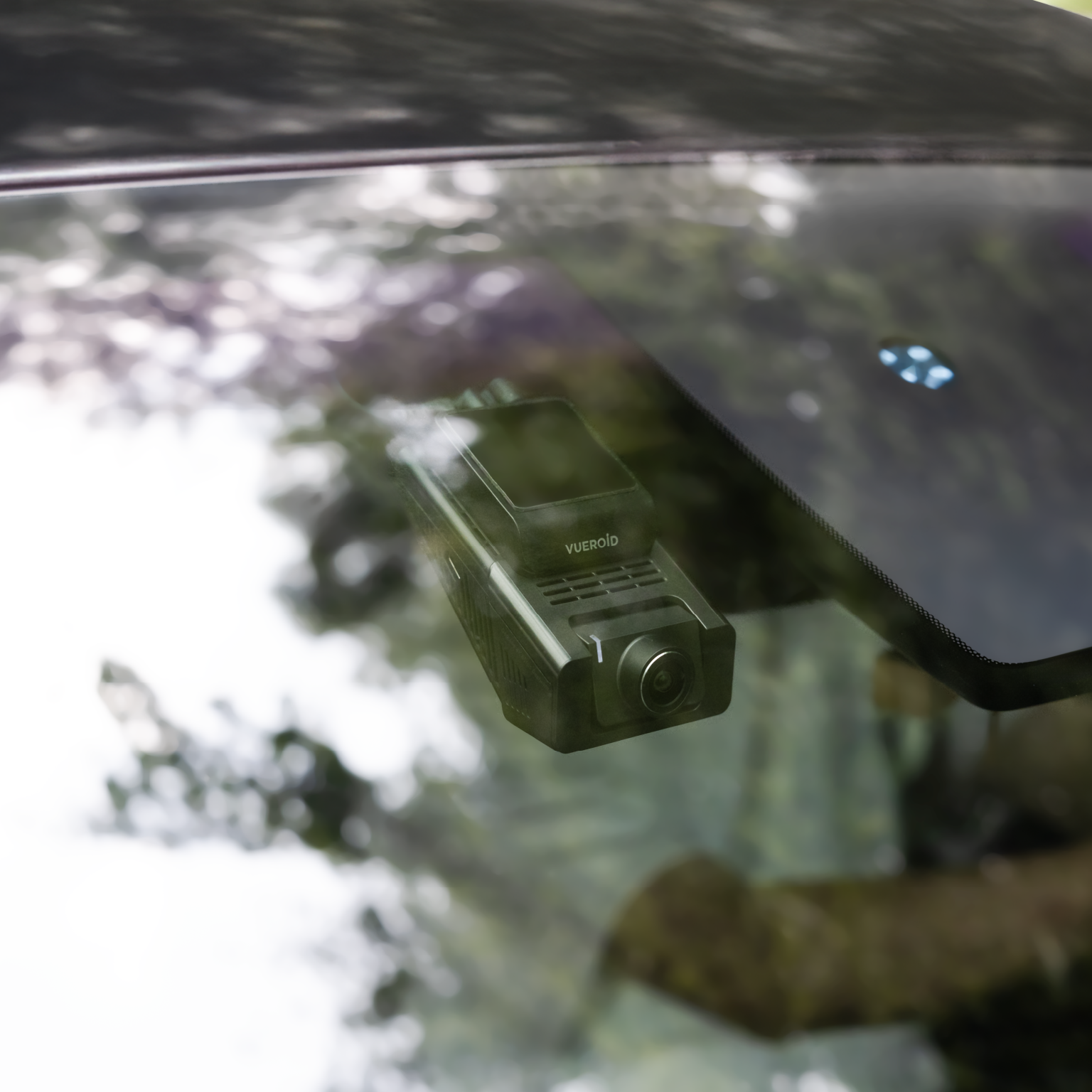 Een zwarte dashcam is gemonteerd op een voorruit van een auto, met weerspiegeling van bomen.