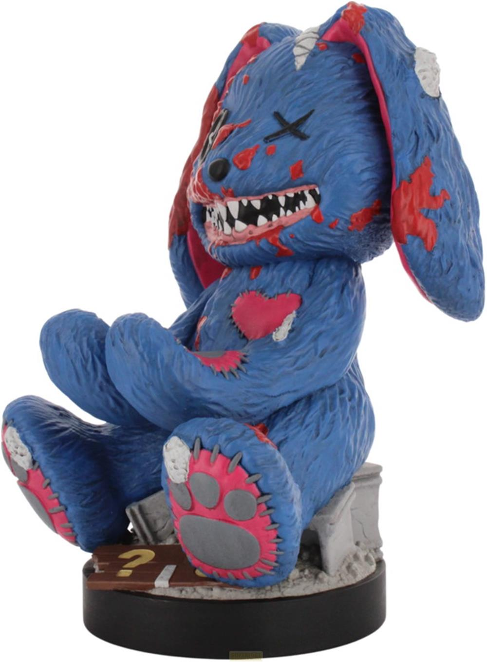 Ein blauer Teddybär mit roten Flecken und gezackten Zähnen sitzt auf einem Sockel mit Fragezeichen.