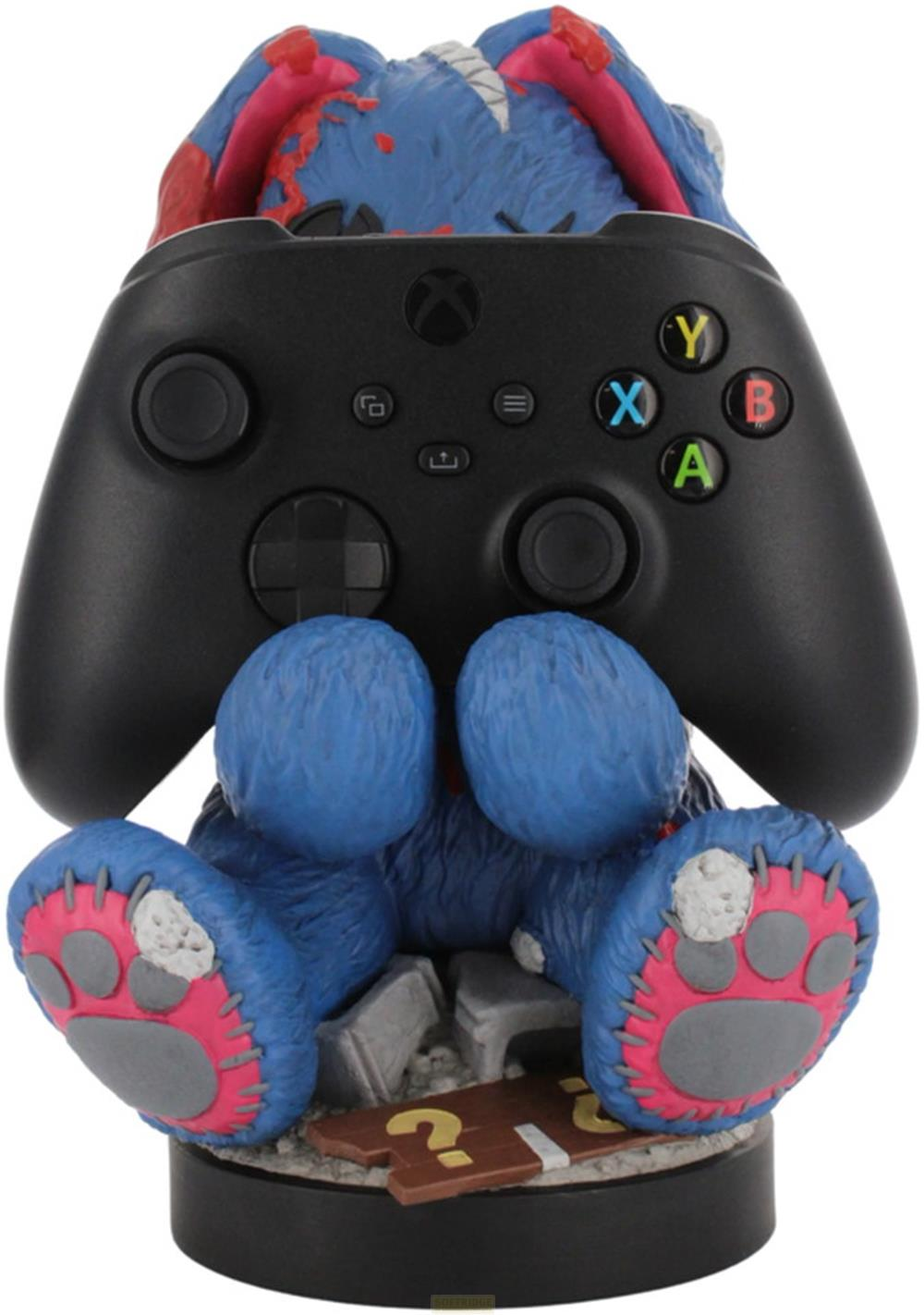 Eine blaue Teddyfigur hält einen schwarzen Xbox-Controller vor sich.