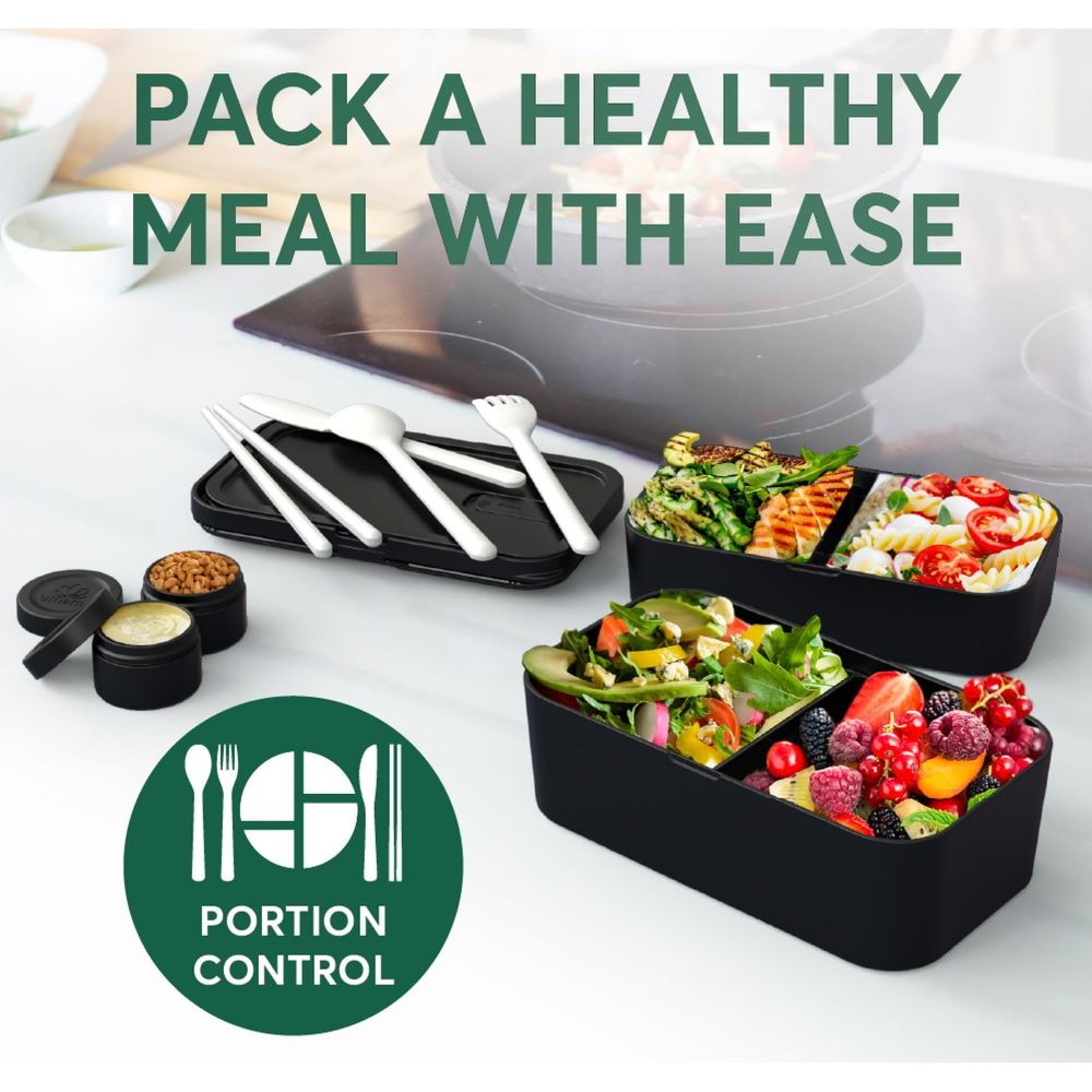 Zwei schwarze Bento-Boxen mit gesunden Lebensmitteln und Besteck.