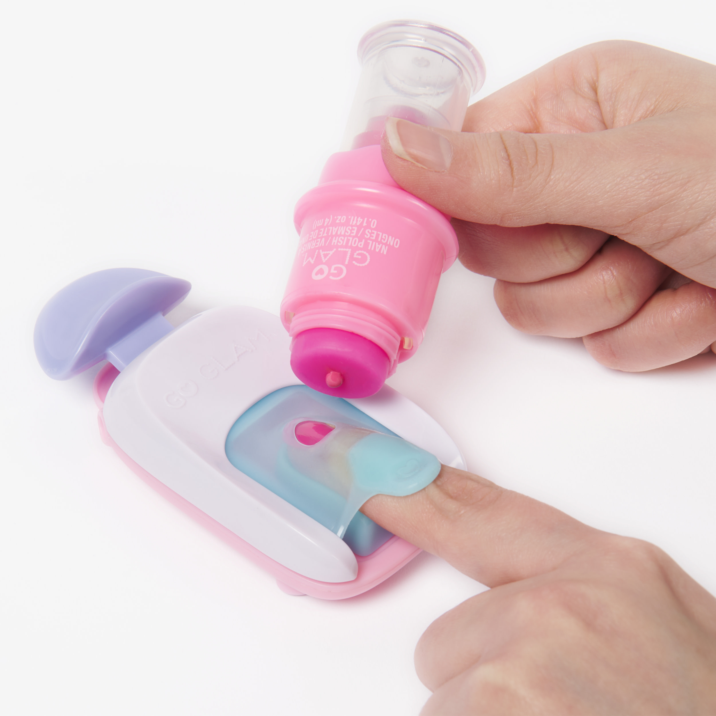 Una mano usa un aplicador de esmalte rosa en un dedo.