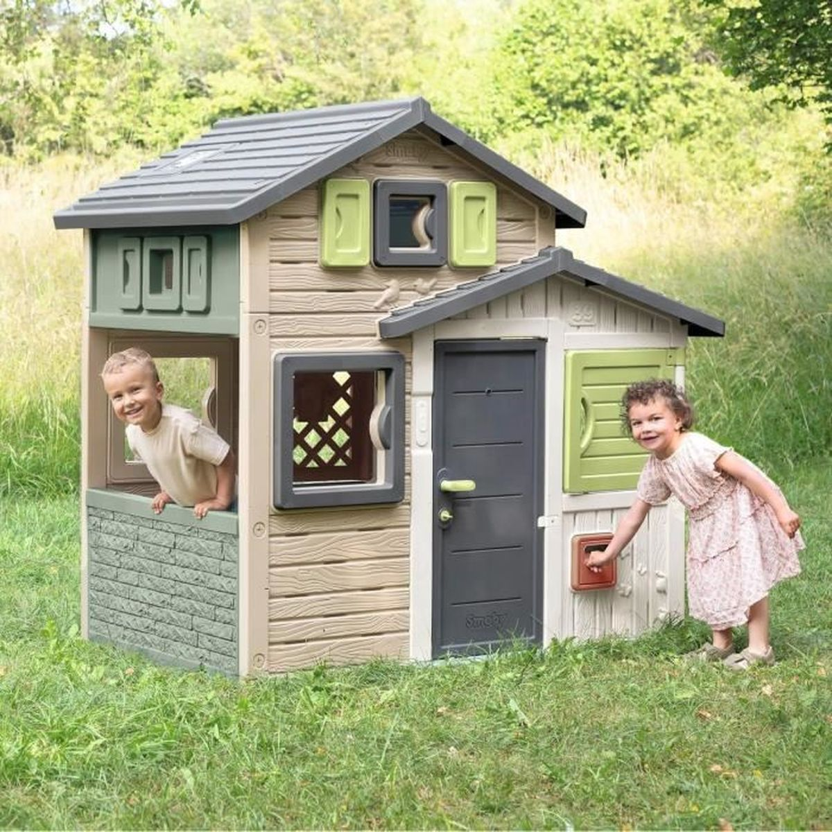 Due bambini giocano davanti a una casa giochi colorata all'aperto.