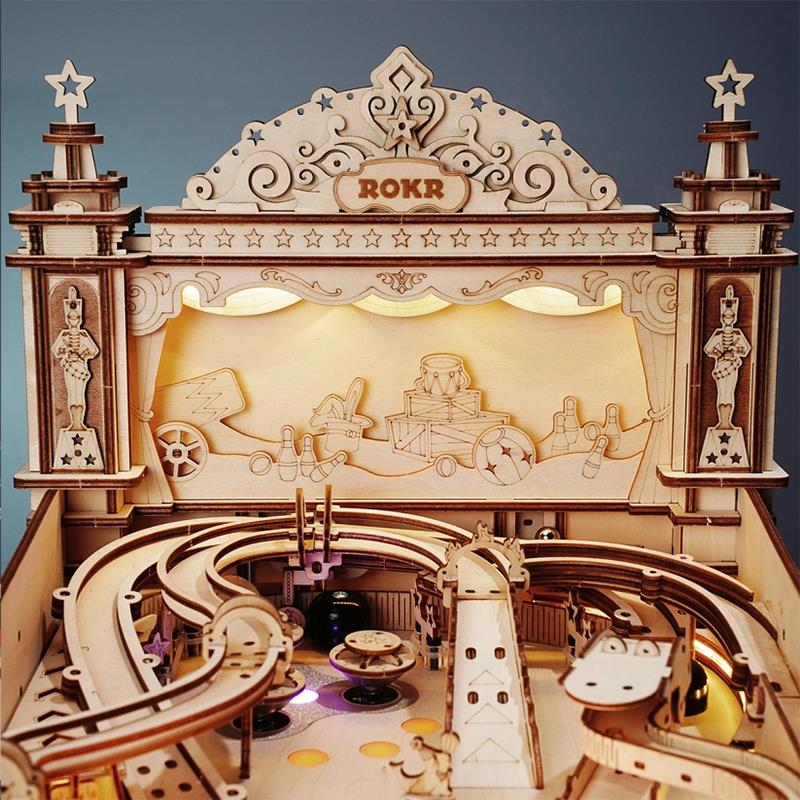 Hölzerne ROKR Murmelbahn mit dekorativer Fassade, Nussknackerfiguren und Bowling-Thema.