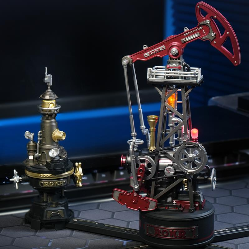 Koyu altıgen bir yüzeyde iki karmaşık, steampunk tarzı mekanik model. Biri kırmızı bir petrol pompası, diğeri altın ve siyah bir kule.