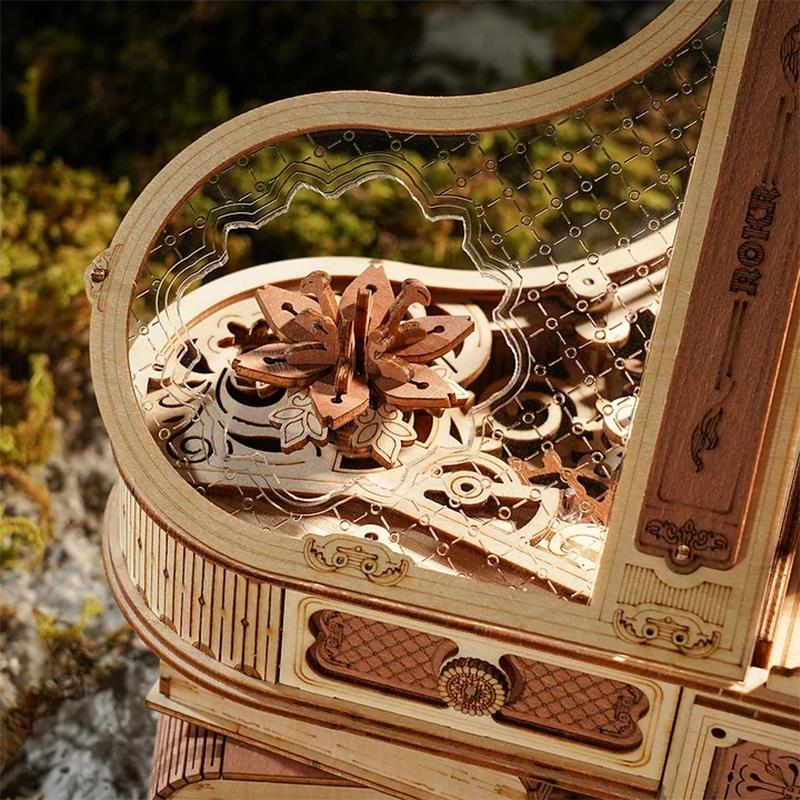 Boîte à musique mécanique en bois aux détails complexes et ornement floral.