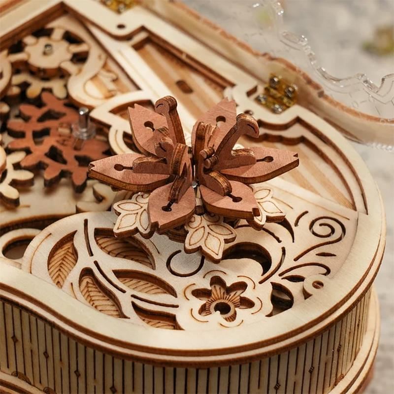 Un modèle détaillé en bois d'une boîte à musique avec engrenages et une fleur en bois.