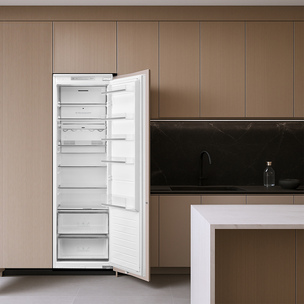 Un refrigerador abierto y vacío en una cocina moderna con gabinetes marrones.