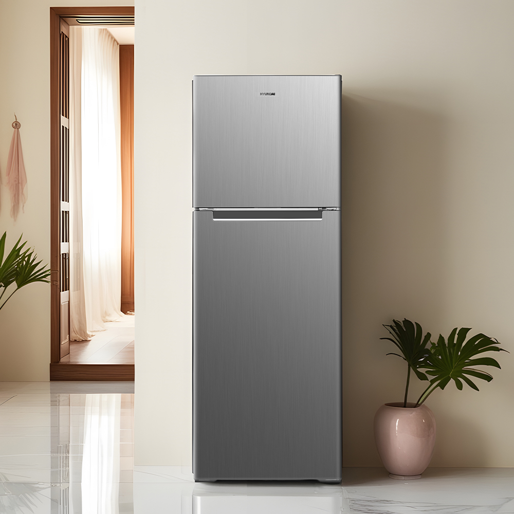 Un refrigerador plateado se encuentra en una habitación luminosa junto a plantas.