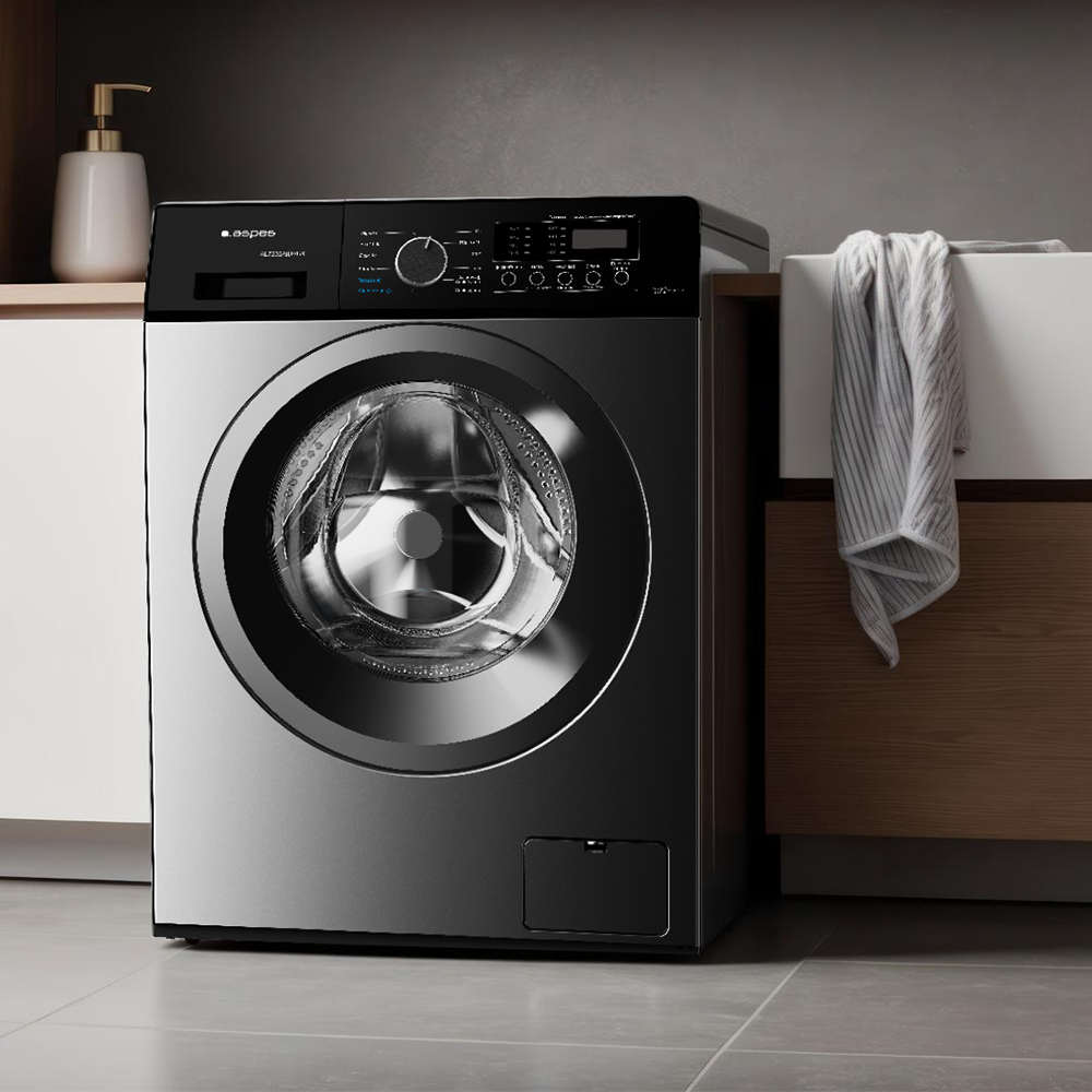 Una lavadora moderna con frente plateado y parte superior negra está en un baño.