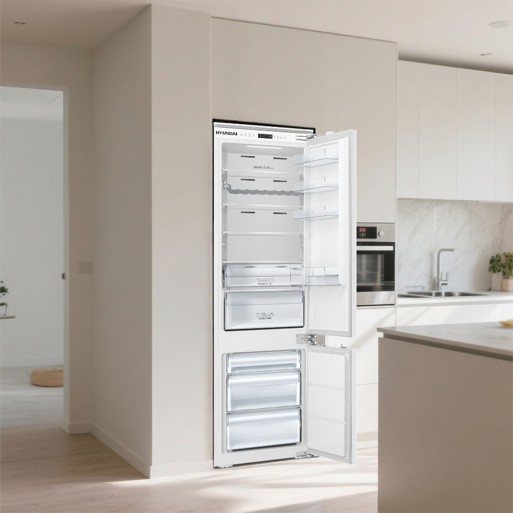 Un refrigerador blanco abierto con varios estantes y cajones en una cocina moderna.