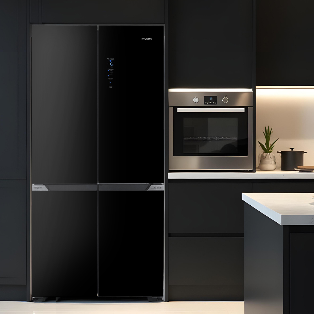 Un refrigerador negro moderno junto a un horno plateado en una cocina elegante.