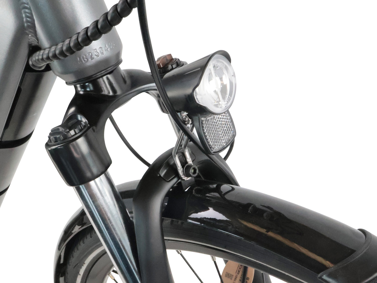 Nahaufnahme von Fahrradgabel, Scheinwerfer und Schutzblech. Silberner Rahmen mit schwarzen Teilen.