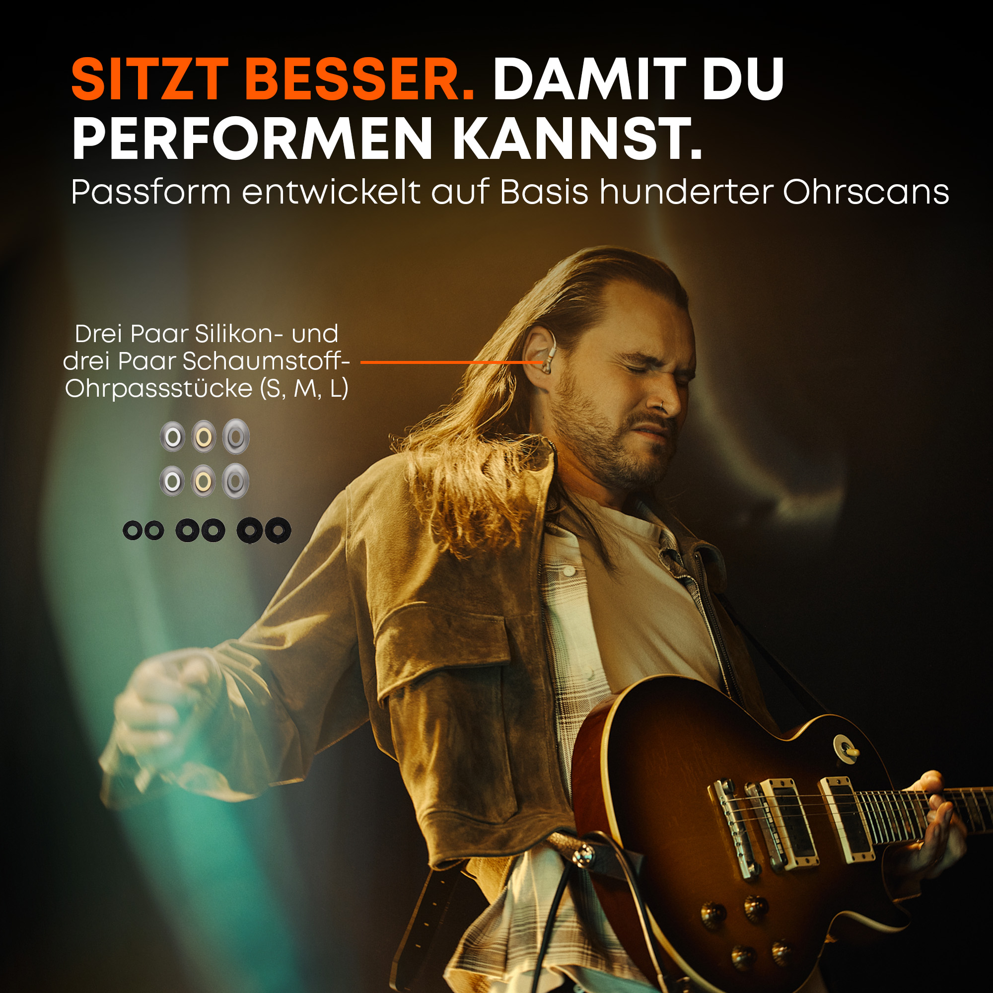 Ein Mann mit langen Haaren spielt Gitarre und trägt Ohrstöpsel.