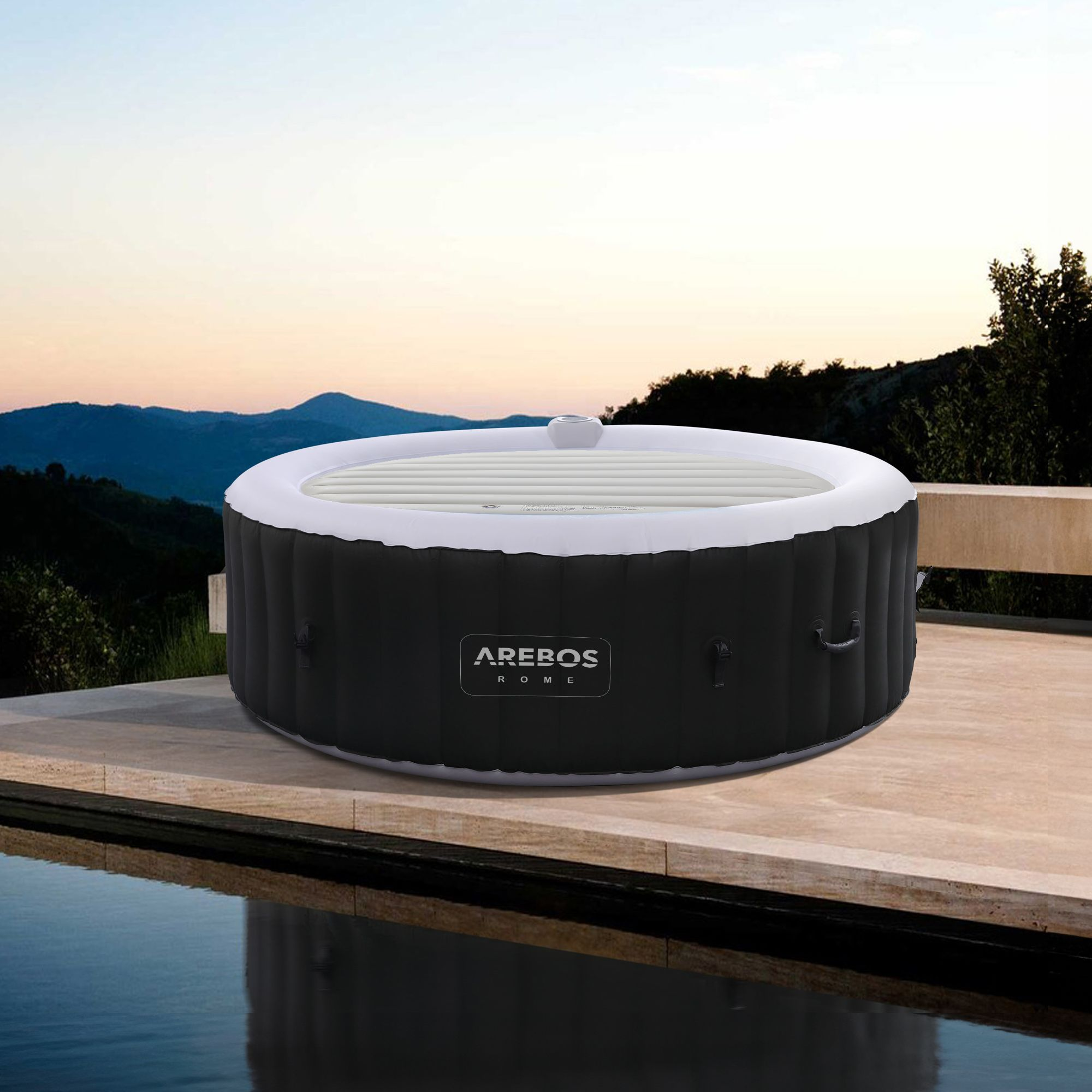 Ein aufblasbarer Whirlpool steht auf einer Terrasse neben einem Pool. Berge im Hintergrund.