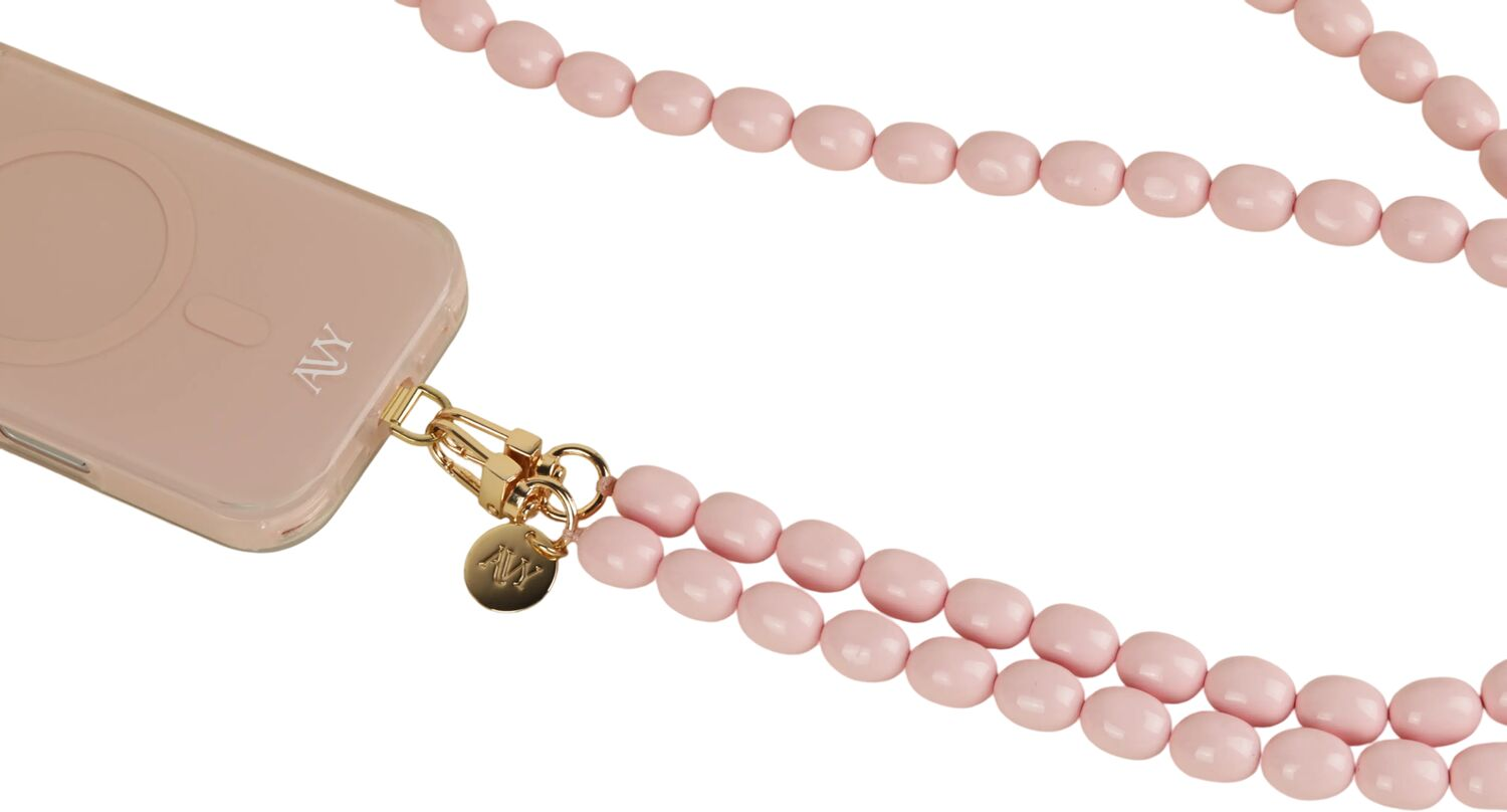 Een roze telefoonhoesje met een parelketting en een gouden bedeltje.