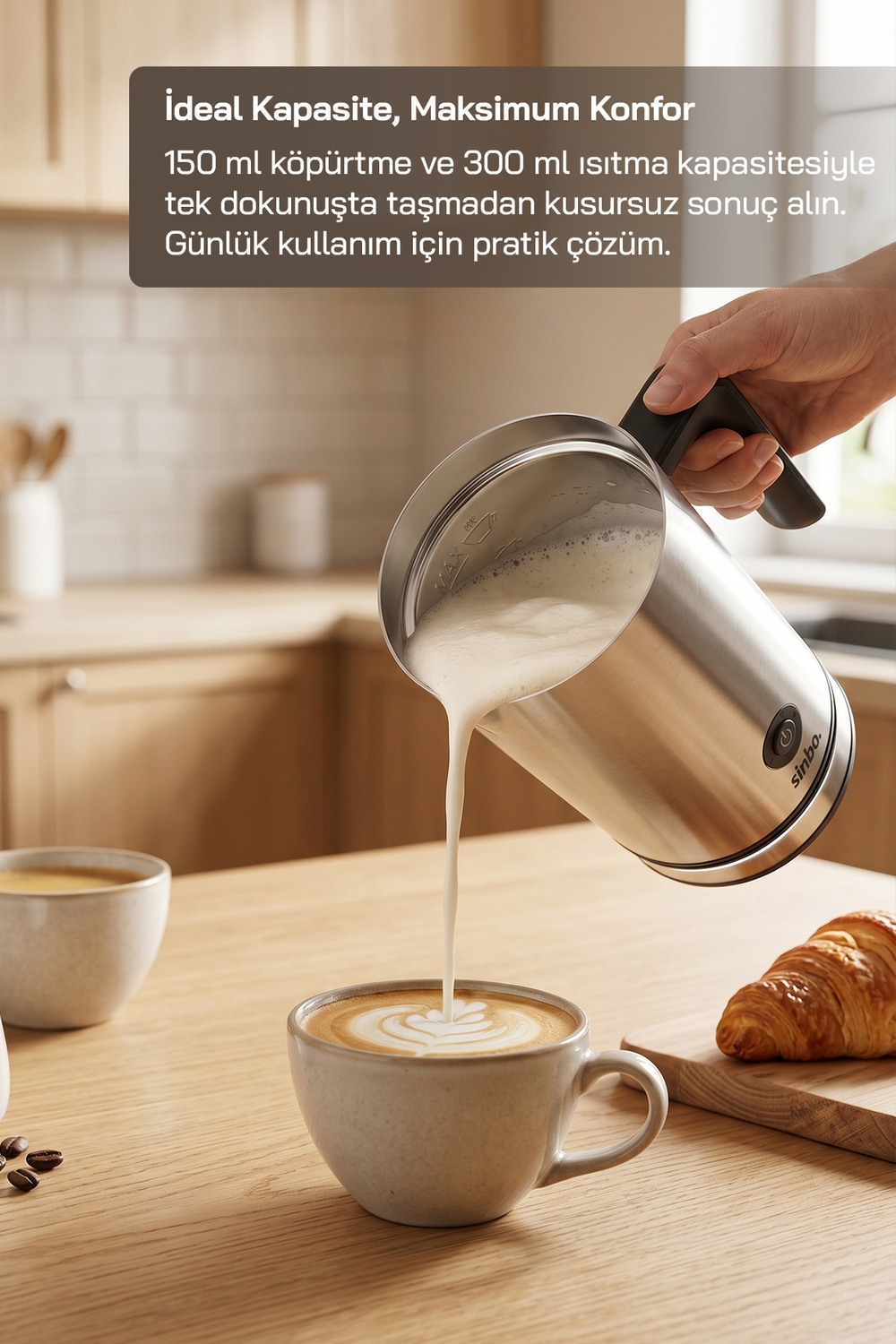Bir el, gümüş rengi süt köpürtücüden bir fincan kahveye köpürtülmüş süt döküyor.