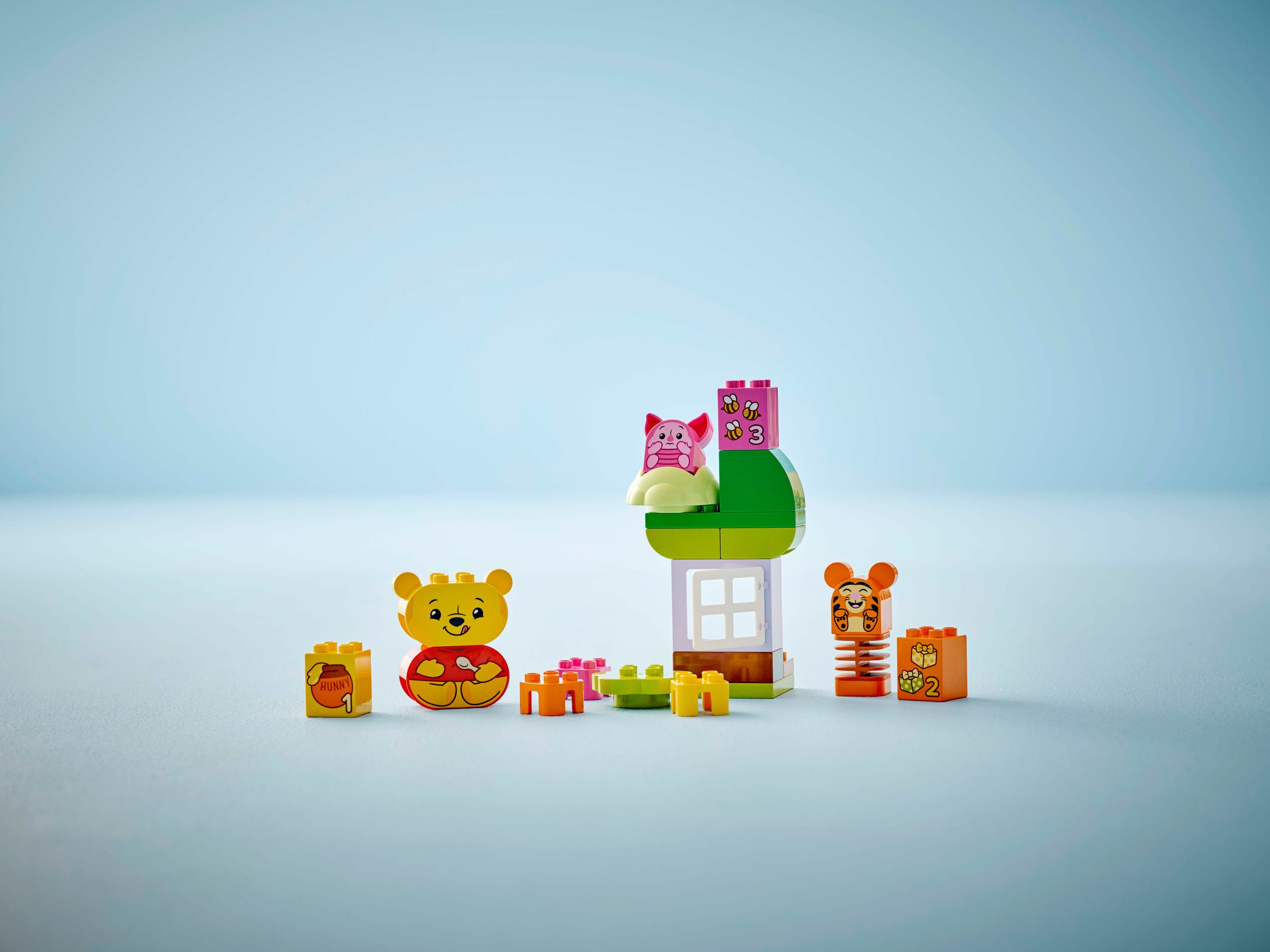 Winnie Puuh, Ferkel und Tigger aus Bausteinen vor hellem Hintergrund.