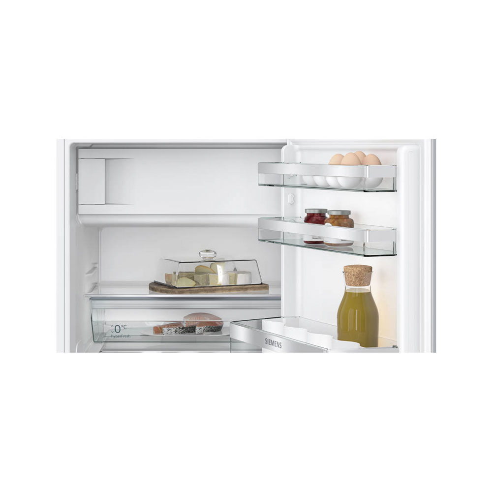 Offener Kühlschrank mit Eiern, Marmelade, Käse und Olivenöl.