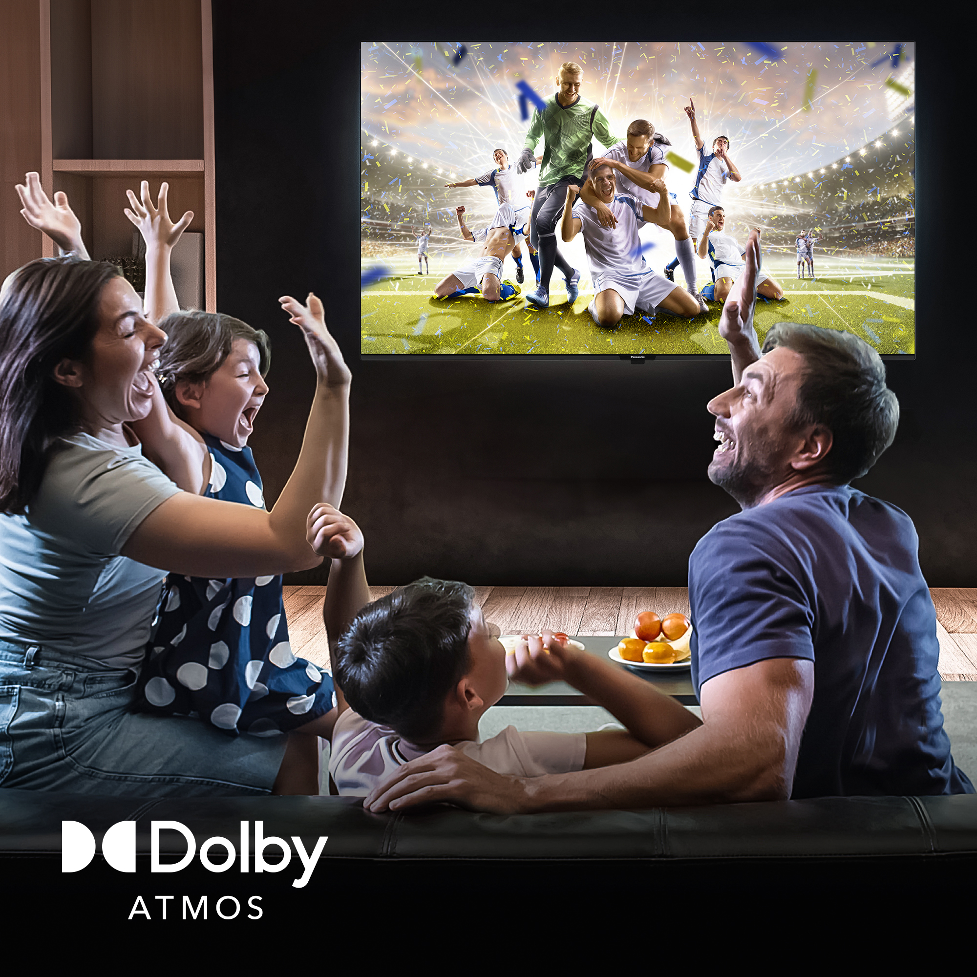 Familie schaut Fußball im Fernsehen, jubelt vor Konfetti.