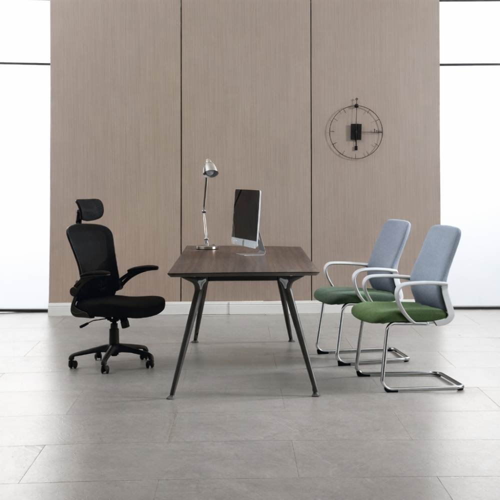 Ufficio con sedia girevole nera, scrivania con computer, lampada e due sedie.