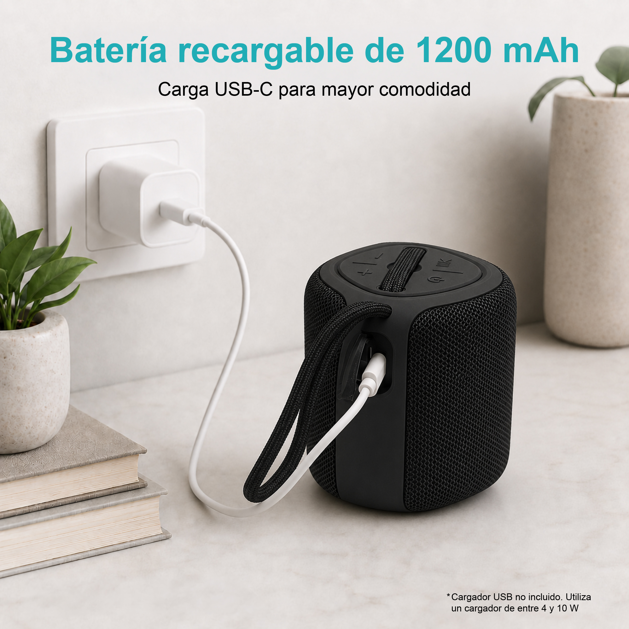 Altoparlante nero in carica tramite USB-C, accanto a libri e una pianta.