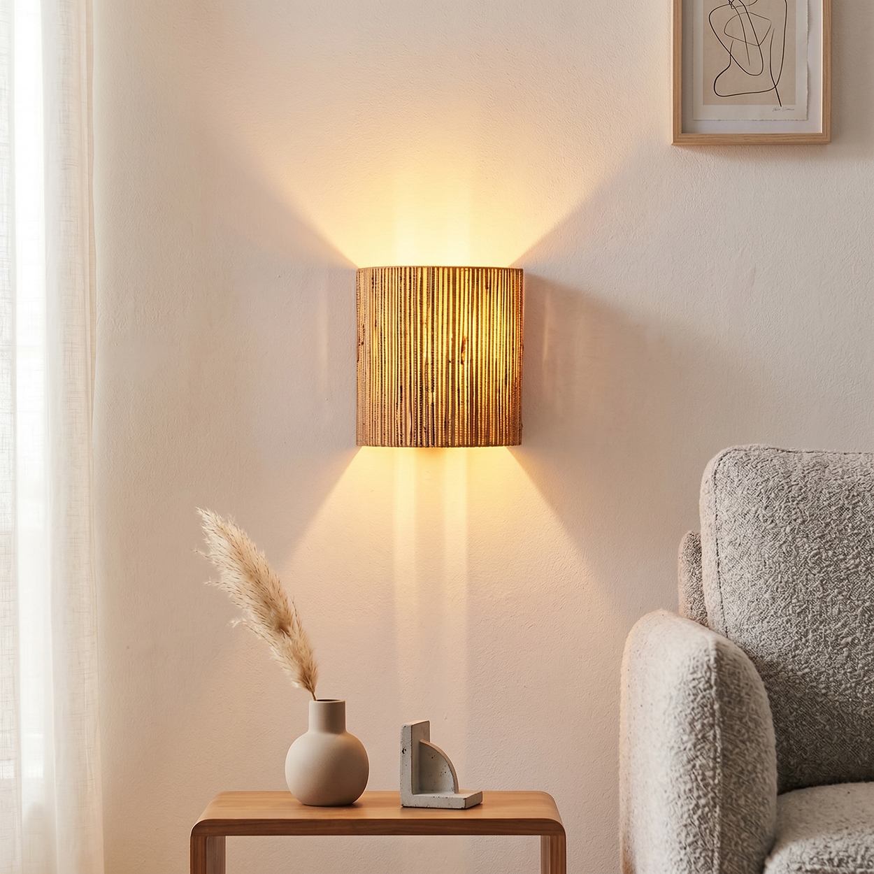Braune Wandleuchte aus Rattan über einem Tisch mit Vase und Büchern.