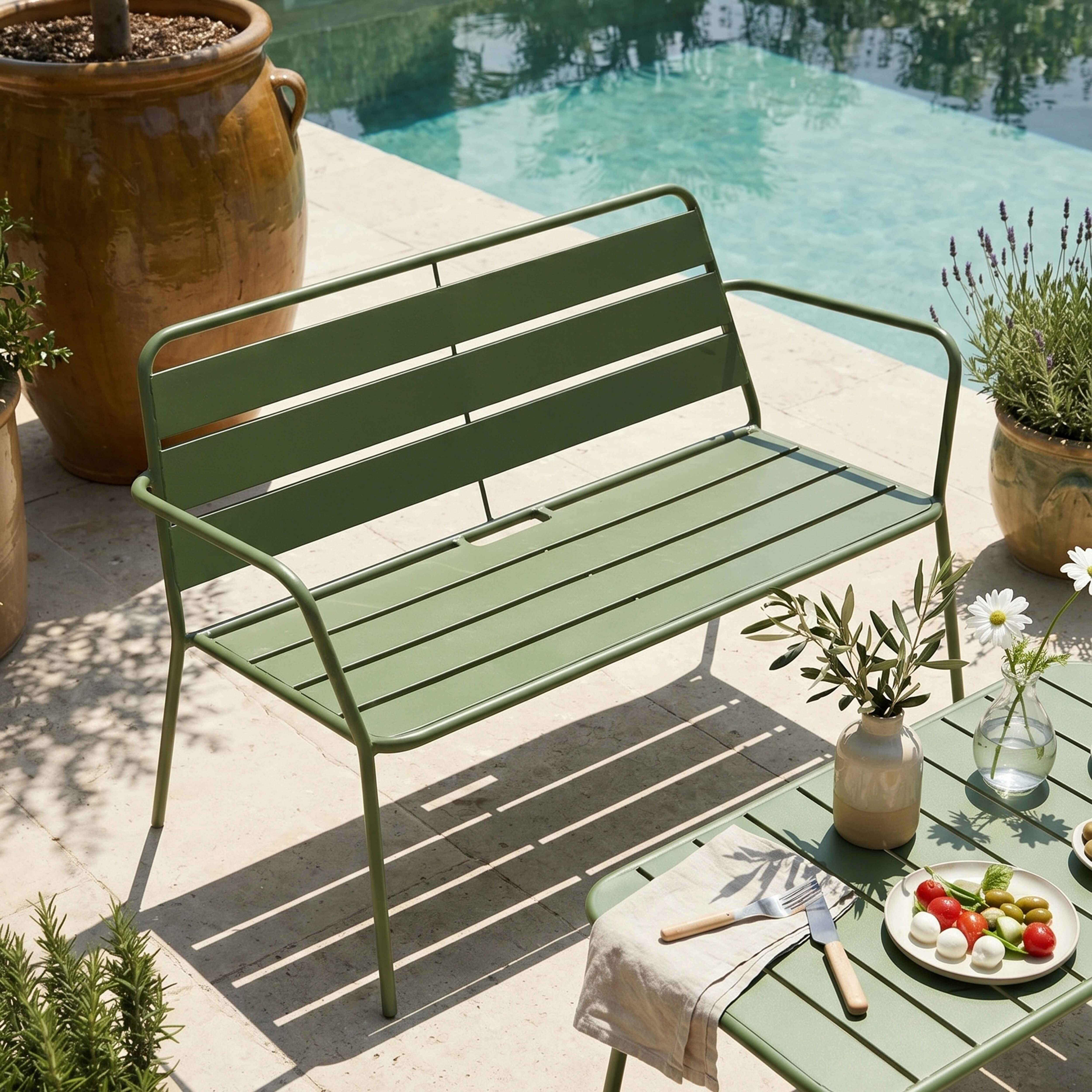 Grüne Gartenbank und Tisch am Pool mit Vorspeisen, Pflanzen und einem großen braunen Topf.