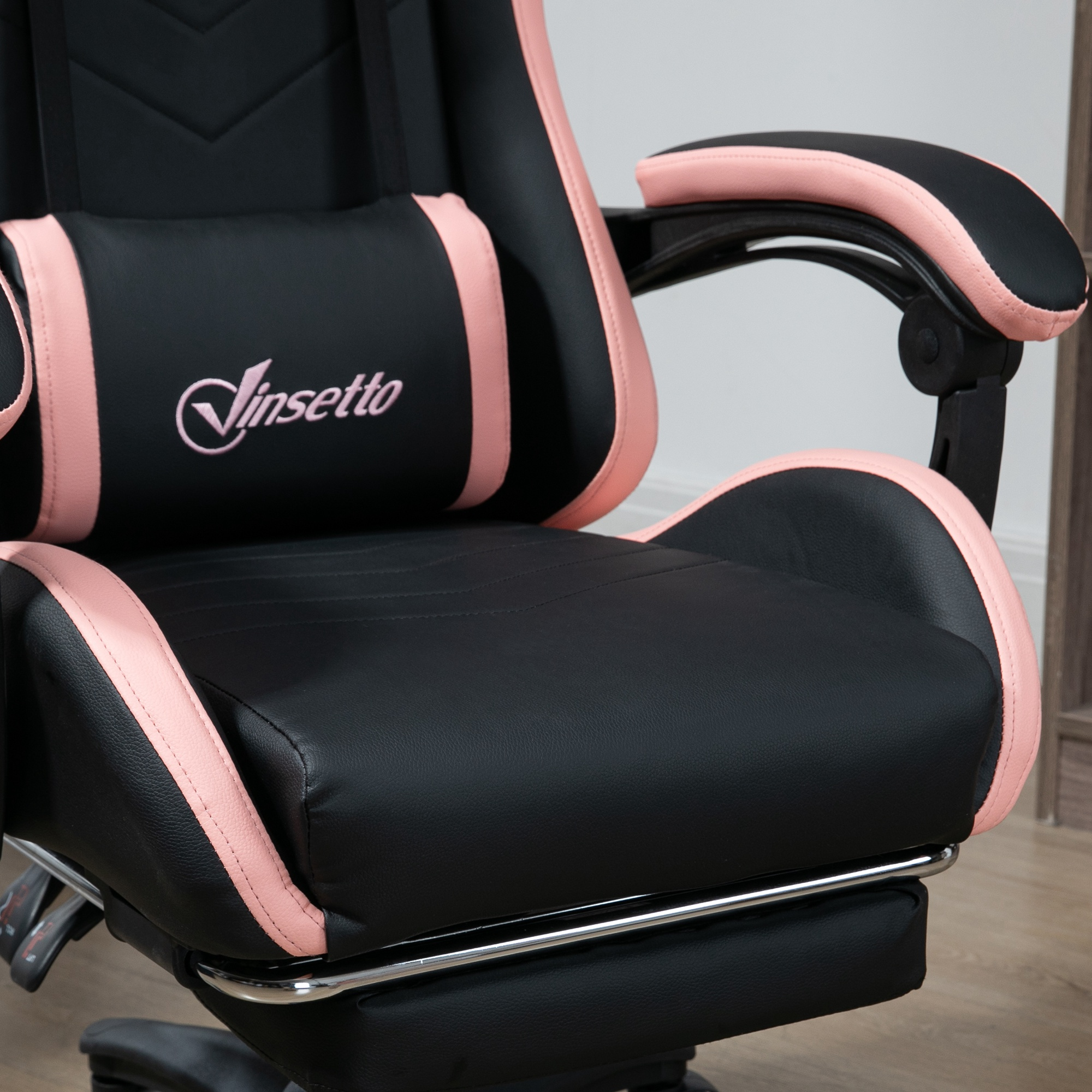 Sedia da gaming nera con accenti rosa su sedile, schienale e braccioli.