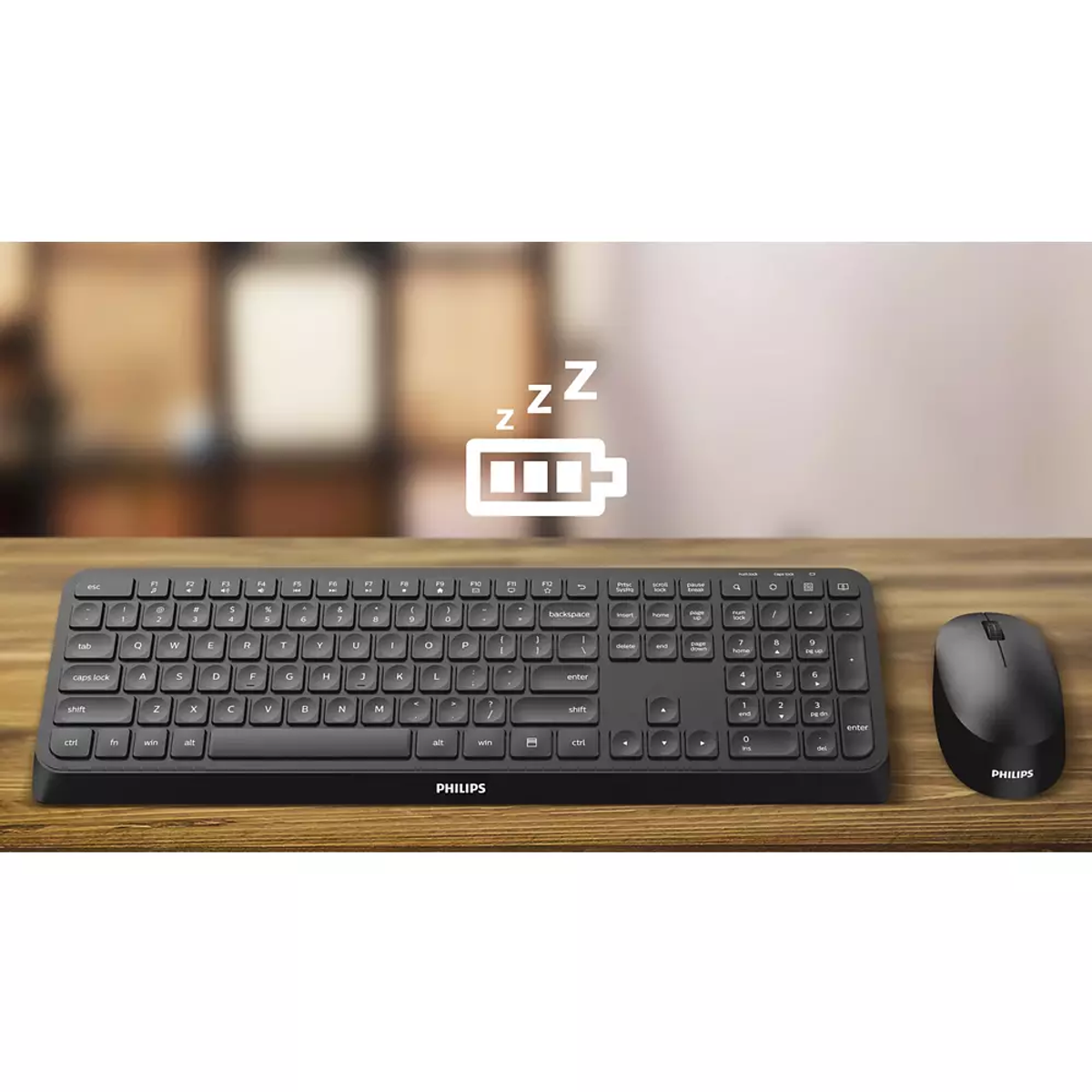 Teclado y ratón Philips negros sobre mesa de madera, con icono de batería