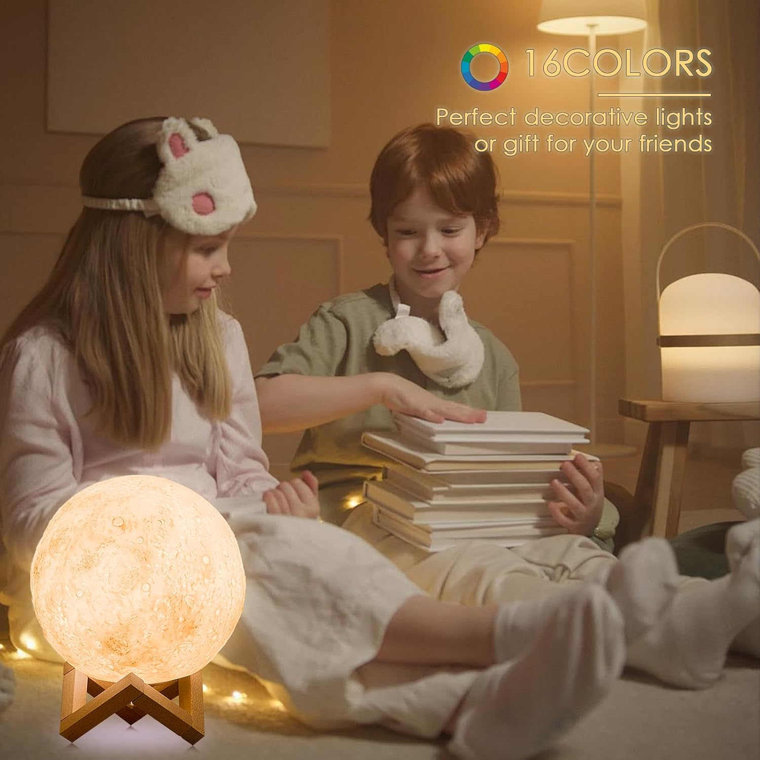 Zwei Kinder sitzen auf dem Boden. Eine Mondlampe leuchtet neben ihnen.