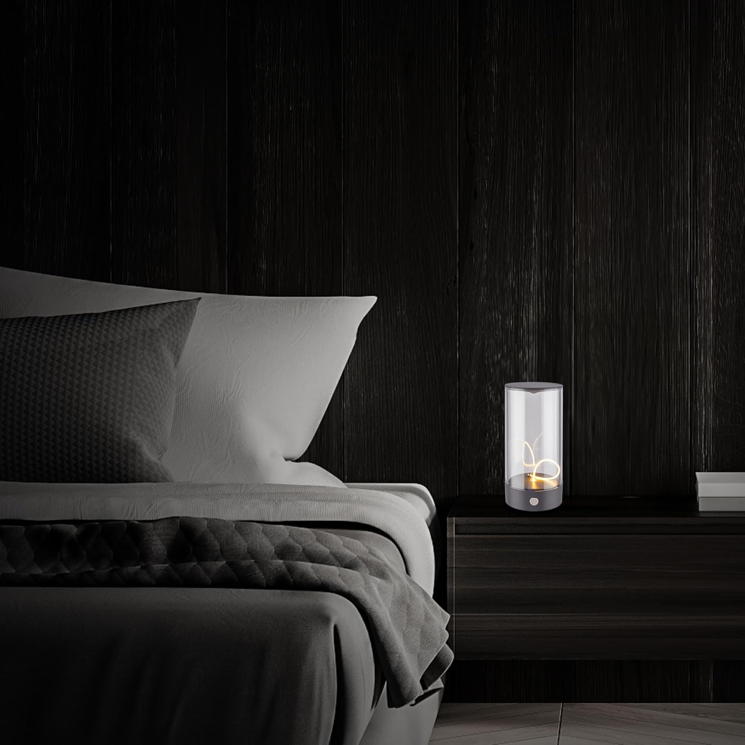 Ein Nachttisch mit einer Lampe und einem Bett daneben, dunkle Holzwand.